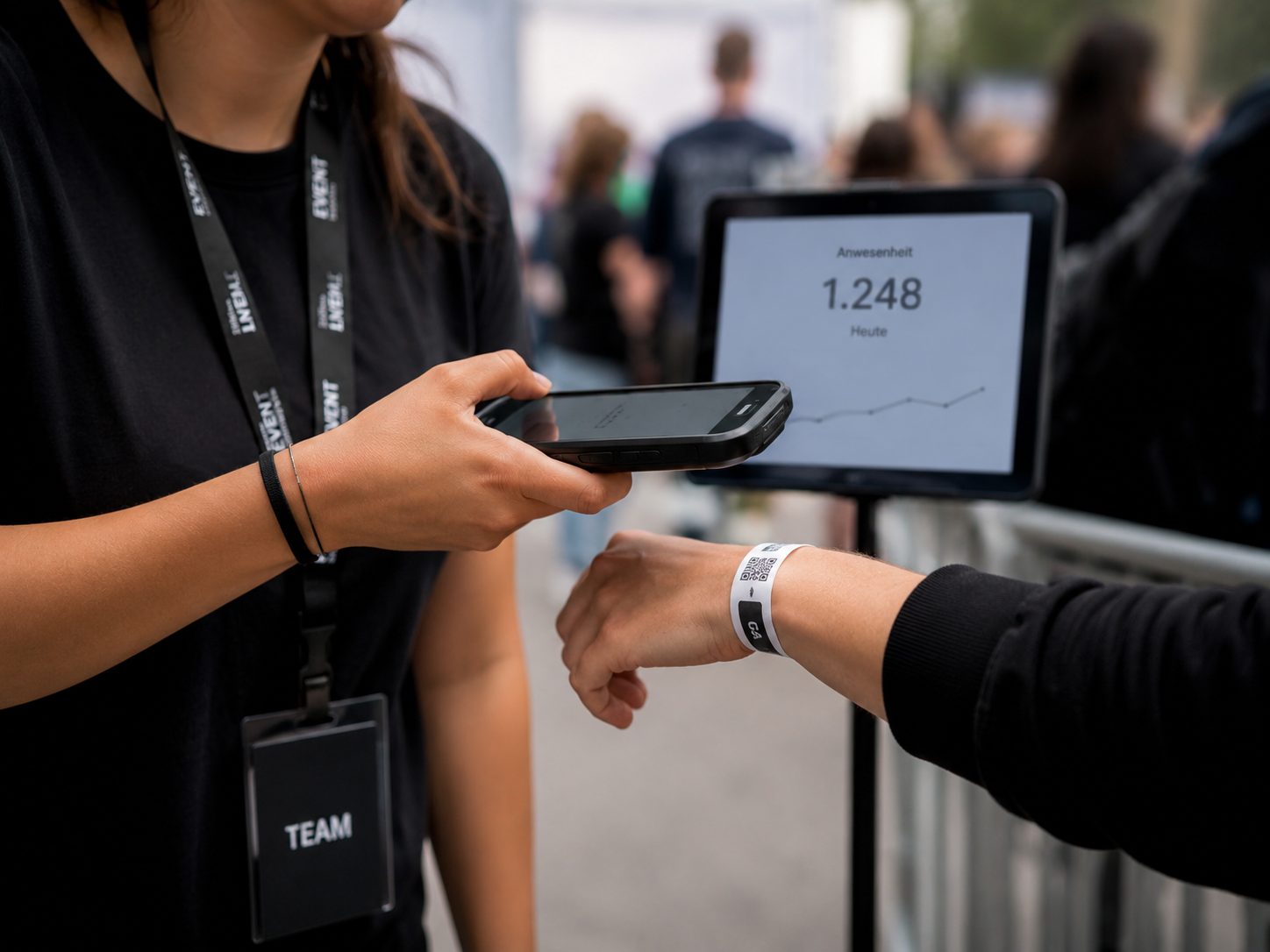 Scan eines QR-Armbands am Einlass, das Tablet zeigt den Event KPI Anwesenheit in Echtzeit