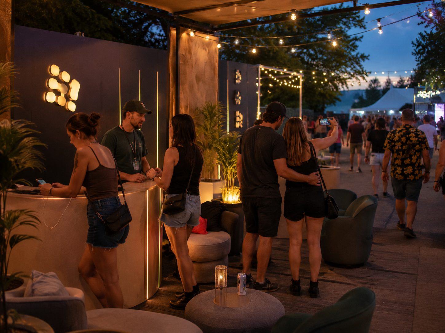 Abendbetrieb auf einer anderen Aktionsfläche: beleuchtete Theke und Sitzgruppe unter einer überdachten Lounge.