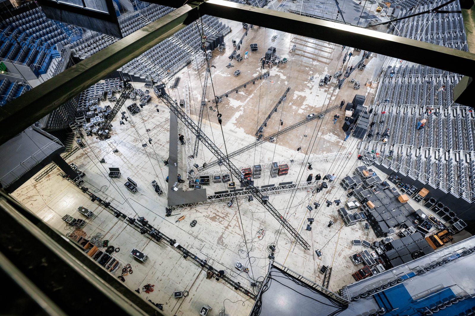 Veranstaltungsplanung in der Arena: Blick von der Hallendecke auf Traversen, Flightcases, Bühnenfläche und Bestuhlung