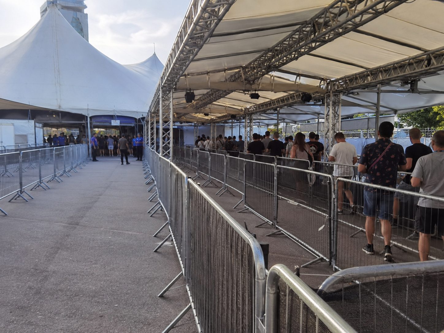 Überdachte Wartezone vor einem Veranstaltungseinlass schützt wartende Besucher vor Regen und Sonne