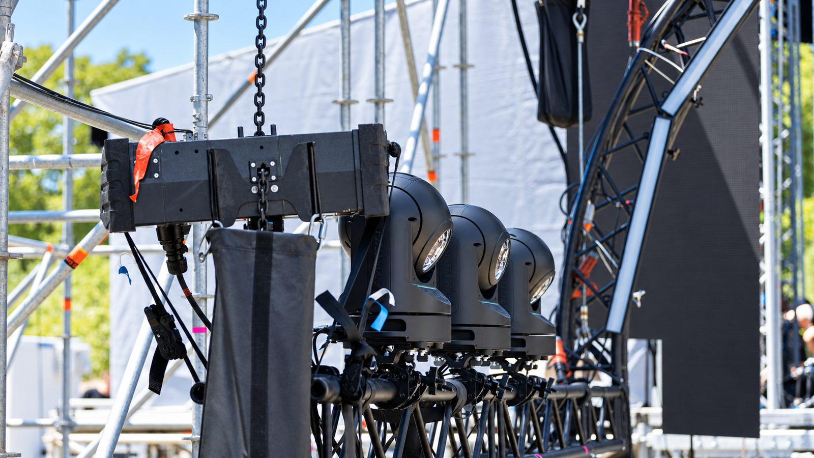 Dry Hire hat Grenzen: Moving-Head-Scheinwerfer und ein Line-Array hängen an einer schwarzen Traverse