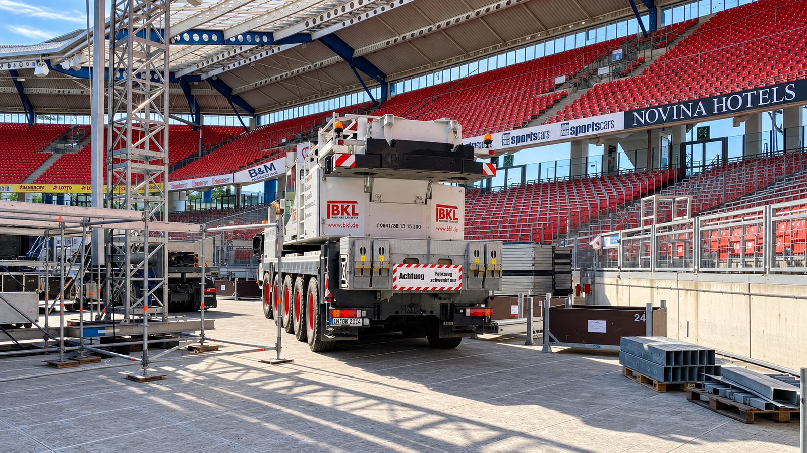 Schwerlastsysteme im Stadion: helle Fahrplatten auf dem Spielfeld, darauf ein Mobilkran beim Aufbau