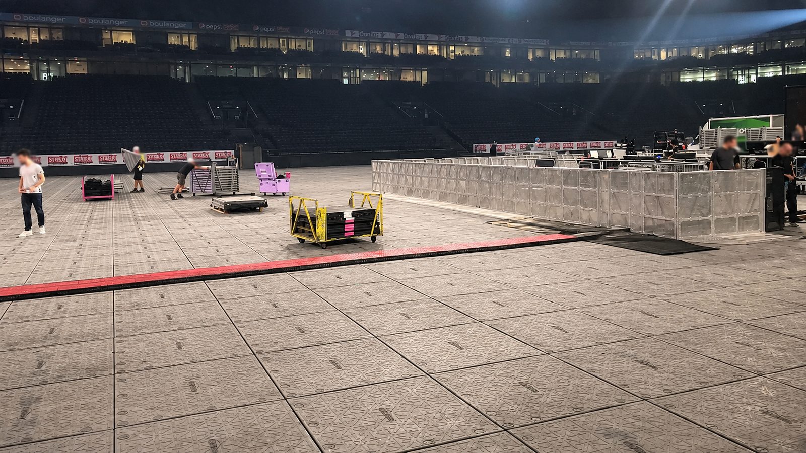 Bodenschutzkonzept Veranstaltung: Arena-Innenraum flächig mit grauen Bodenschutzplatten ausgelegt, rote Kabelbrücke quer