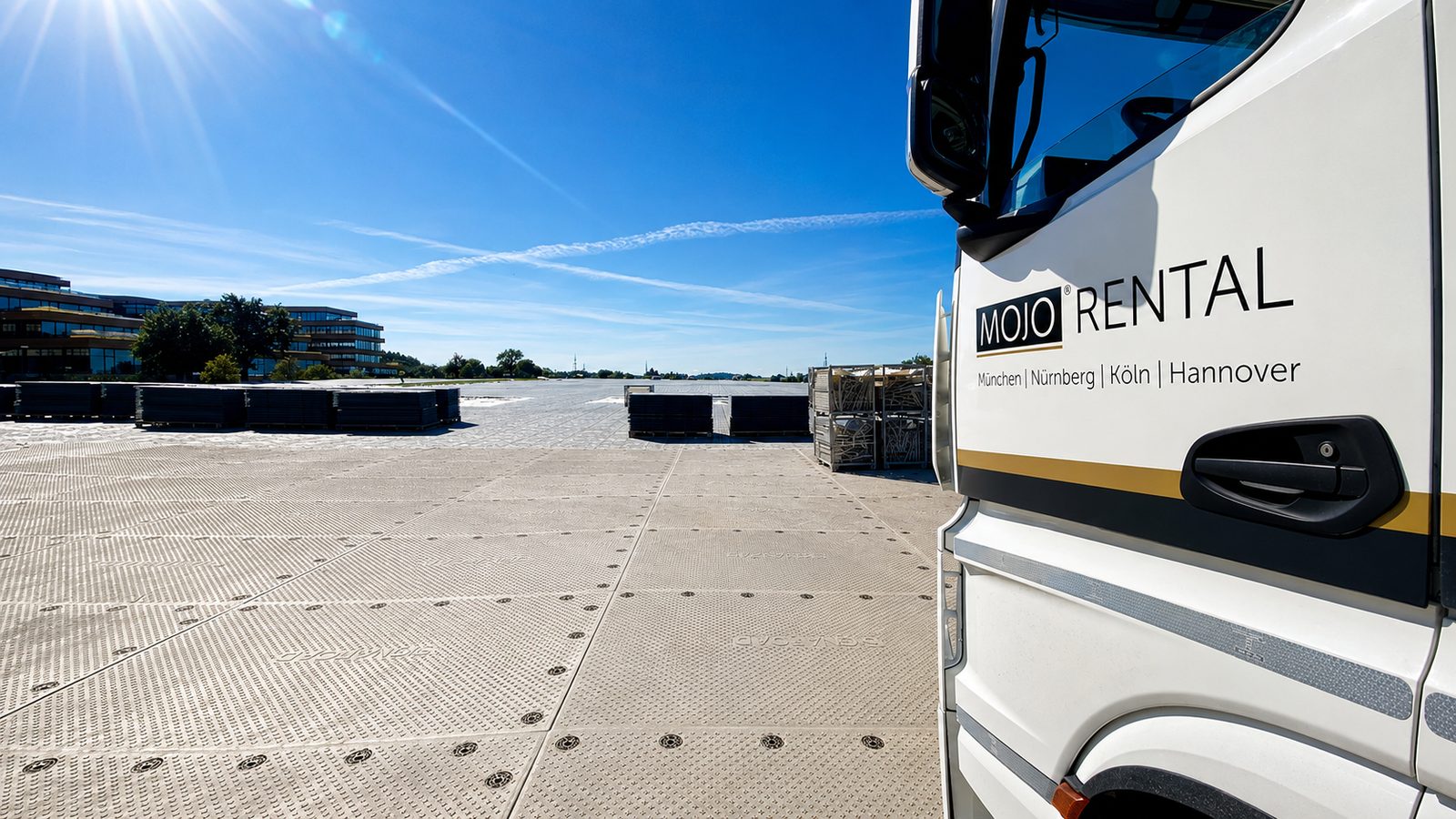 Weißer Lkw von MOJO Rental neben einer weiten Fläche aus hellen Bodenschutzplatten