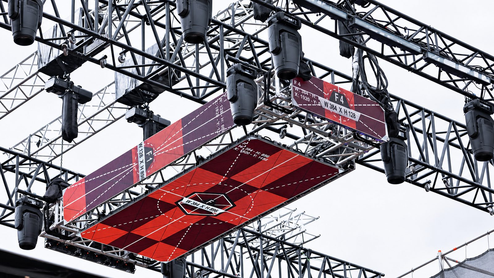 Untersicht auf ein Rigging-Grid aus gekoppelten Vierpunkt-Traversen mit Movingheads und LED-Flächen