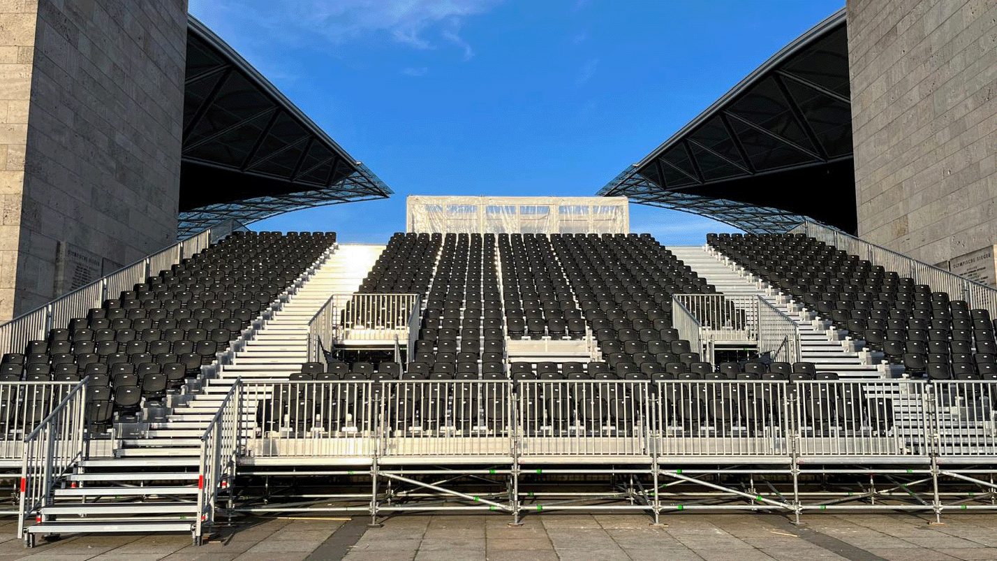 Tribünenplanung: temporäre Tribüne zwischen zwei Stadionpylonen, zwölf Reihen mit Treppengassen und Handläufen.